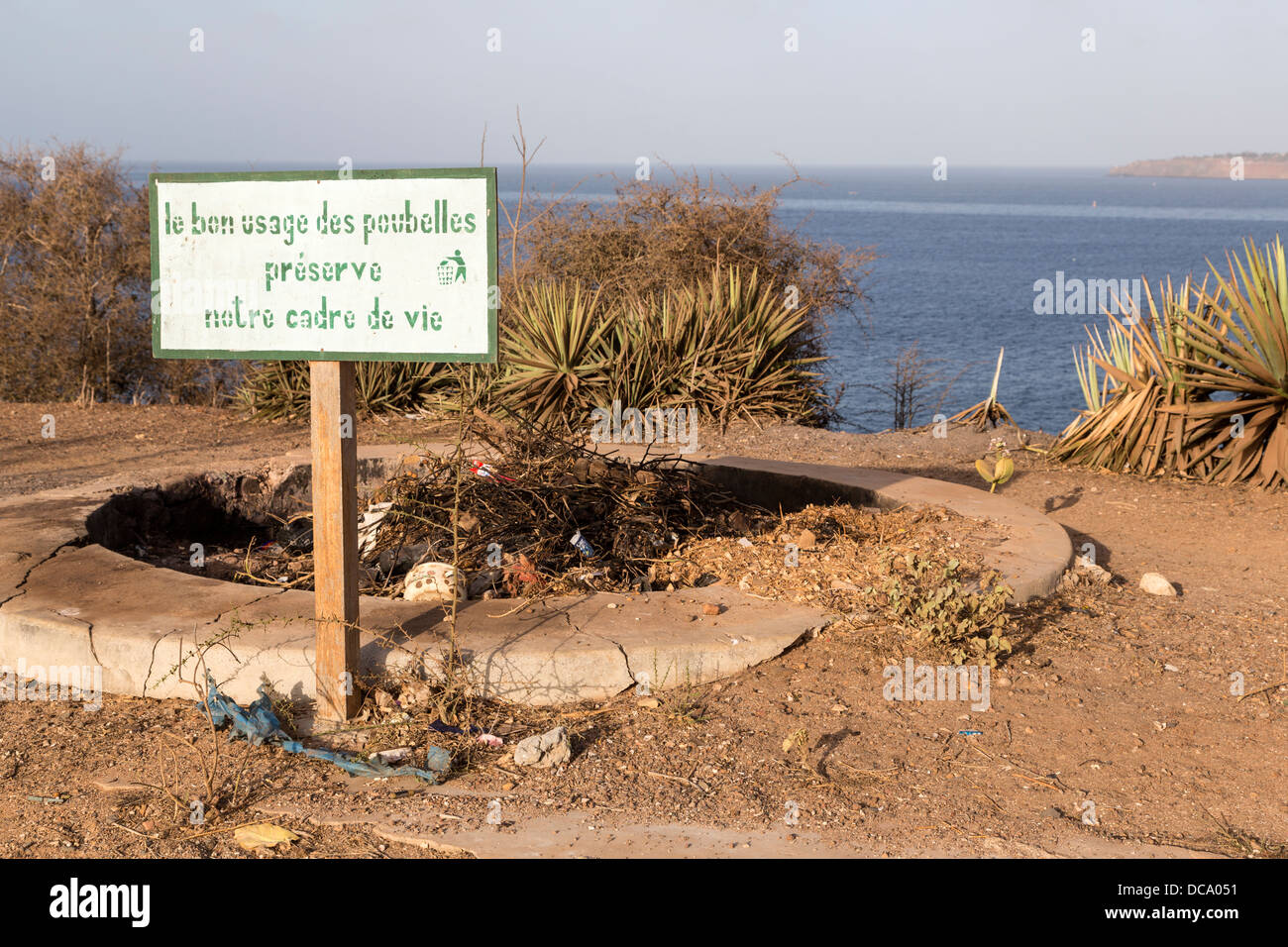 Il segno sul punto più alto dell'isola, afferma che "l'uso corretto dei bidoni della spazzatura conserva il nostro ambiente. " isola di Goree, Senegal. Foto Stock