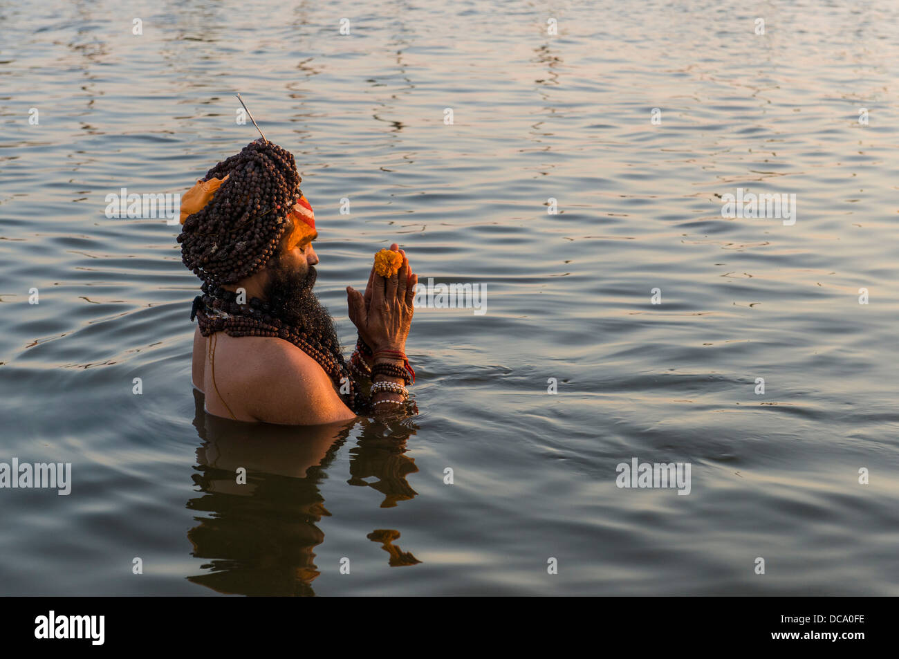 Sadhu, uomo santo, l'assunzione di un bagno e di pregare in Sangam, alla confluenza dei fiumi Gange e Yamuna e Saraswati, appena prima di Foto Stock