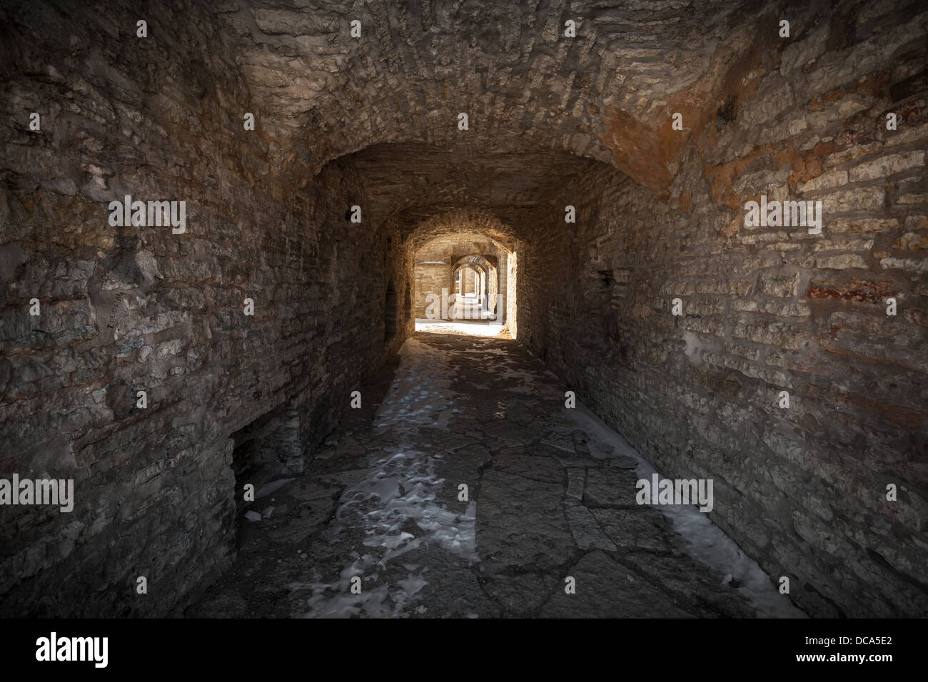 Vecchia fortezza in pietra pietra scura prospettiva di tunnel con estremità incandescente Foto Stock
