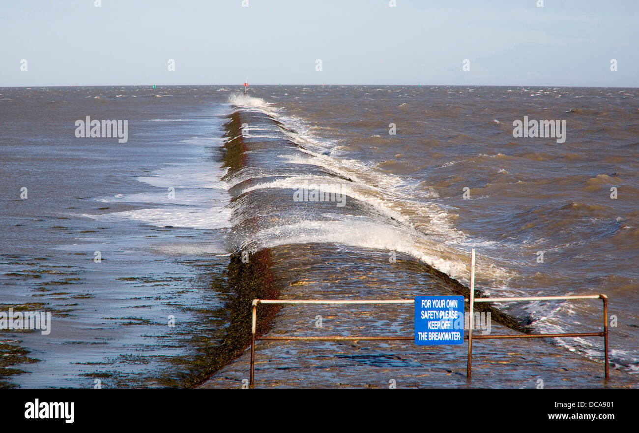 Lavaggio onde oltre lungo frangiflutti costiere Dovercourt Harwich Essex Inghilterra Foto Stock