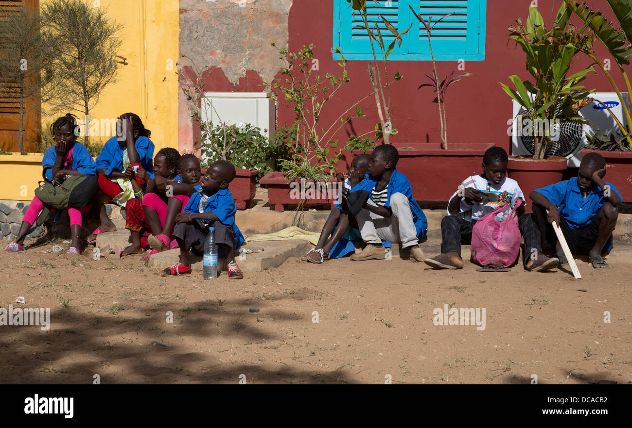 Scuola senegalesi i bambini in attesa per un gruppo di assemblare, isola di Goree, Senegal. Foto Stock
