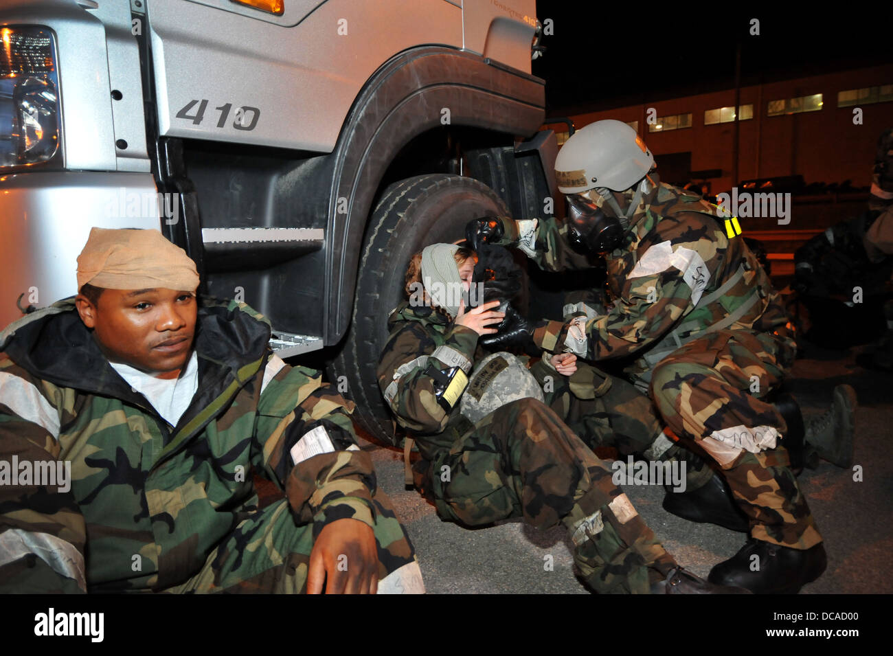 Il Mag. Douglas Barnes, Logistica Disponibilità Squadron direttore delle operazioni, a destra consente di simulare un ferito ruolo di giocatore mettere sulla sua missione orientata postura di protezione ingranaggio durante un incidente di massa esercizio fisico durante la prontezza operativa esercizio Beverly Midnig Foto Stock