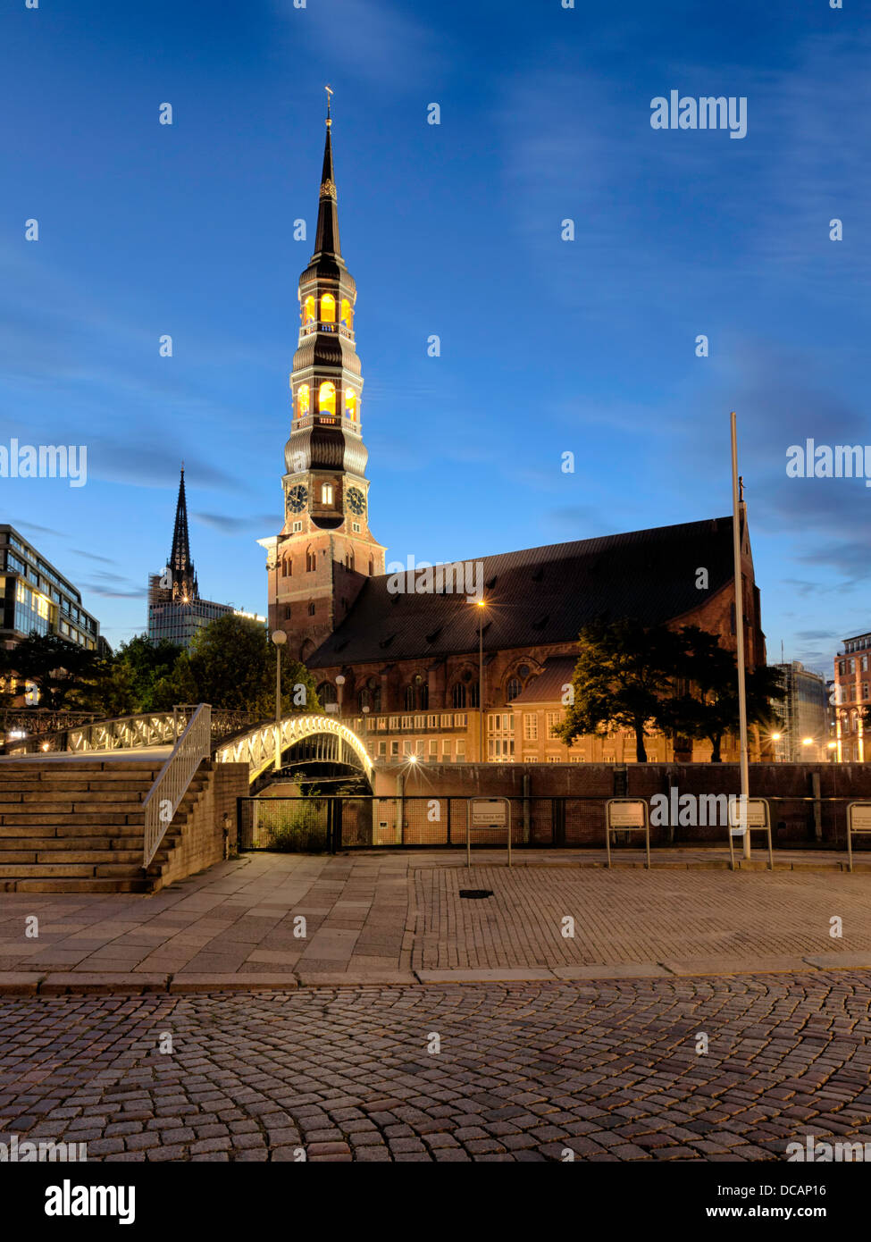 Katharinenkirche (St. Catherine chiesa) vicino ad Amburgo Speicherstadt di notte, guglia di Nikolaikirche in background Foto Stock