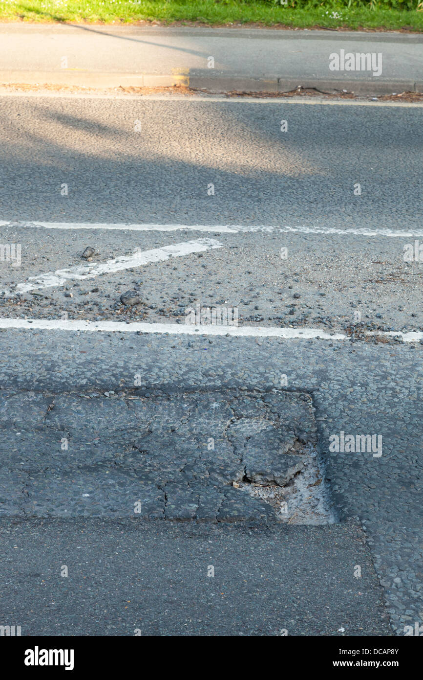 Poveri riparazione stradale risultante in un danneggiamento del manto stradale e pot foro, Nottinghamshire, England, Regno Unito Foto Stock