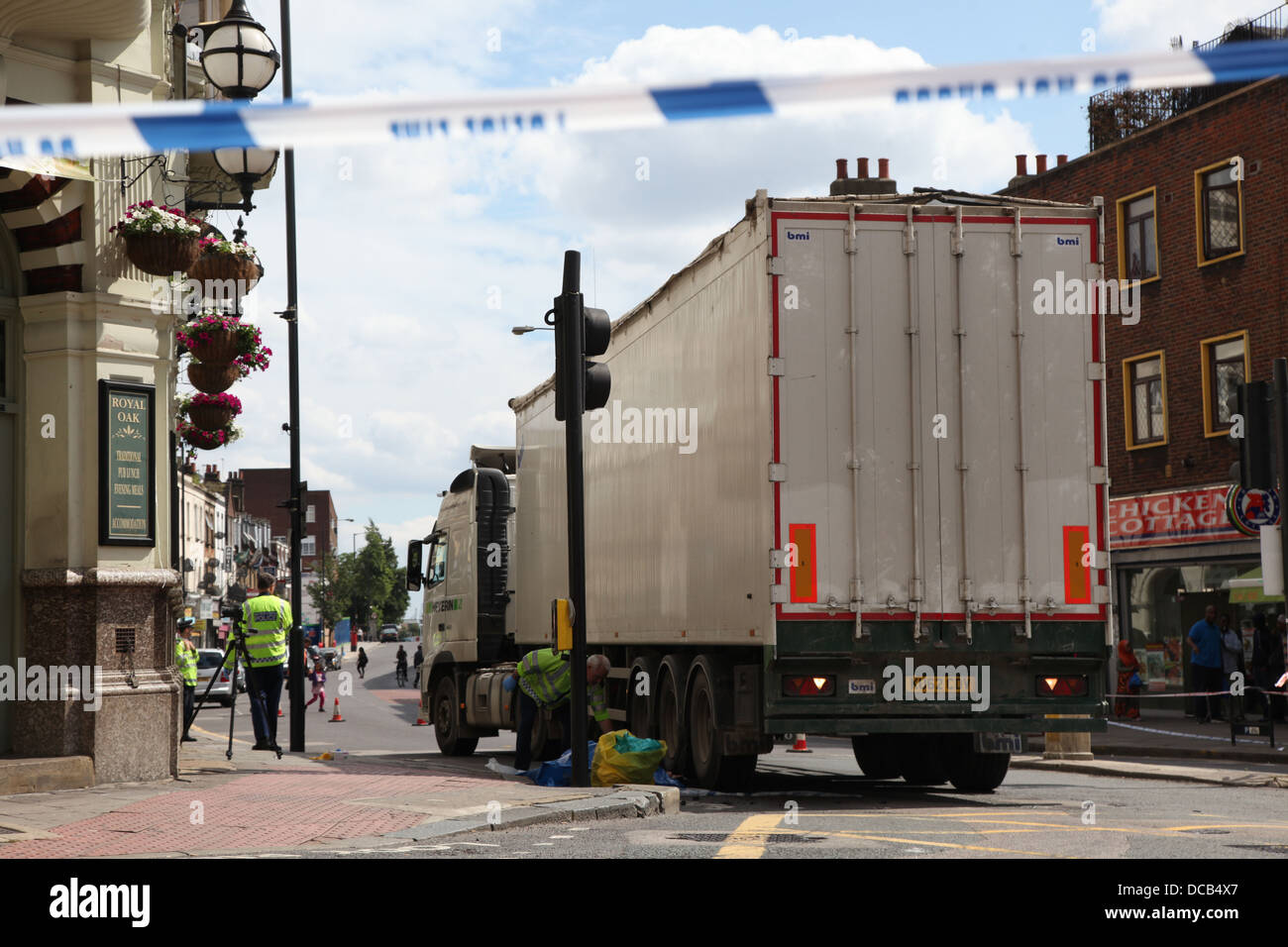 La polizia e gli appaltatori di occuparsi di un autocarro a seguito di un incidente stradale Foto Stock