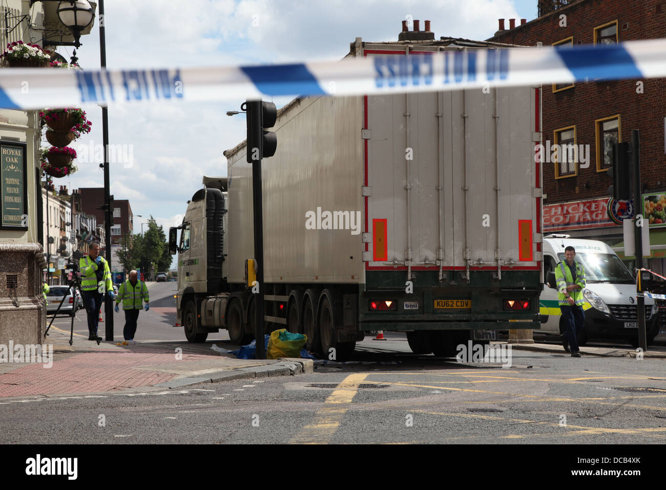 La polizia e gli appaltatori di occuparsi di un autocarro a seguito di un incidente stradale Foto Stock