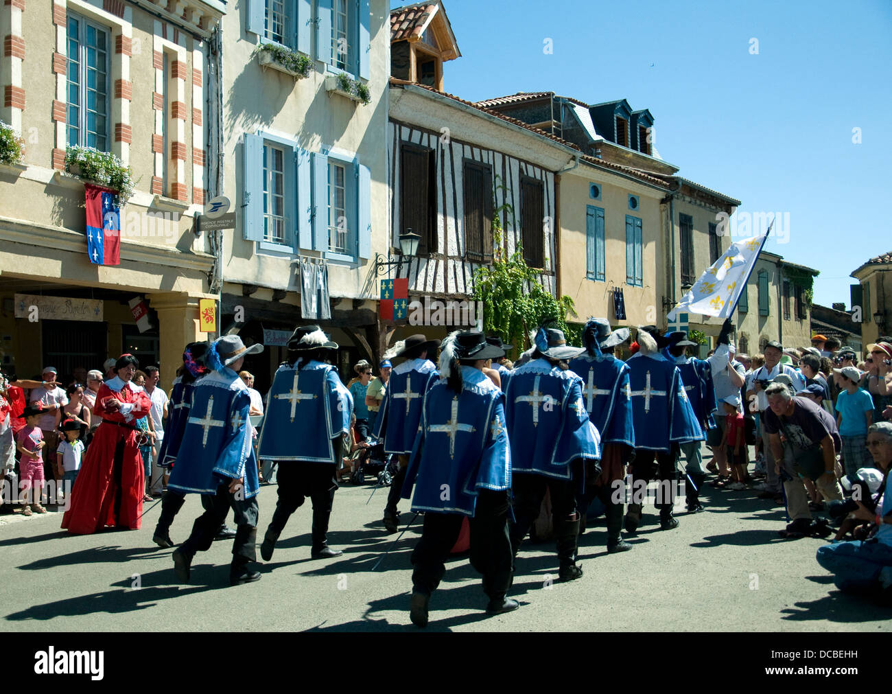 I cadetti de Gascogne marzo fuori Lupiac's village square guardato da un colore rosso-costume 'Cardinal Mazarin" Foto Stock