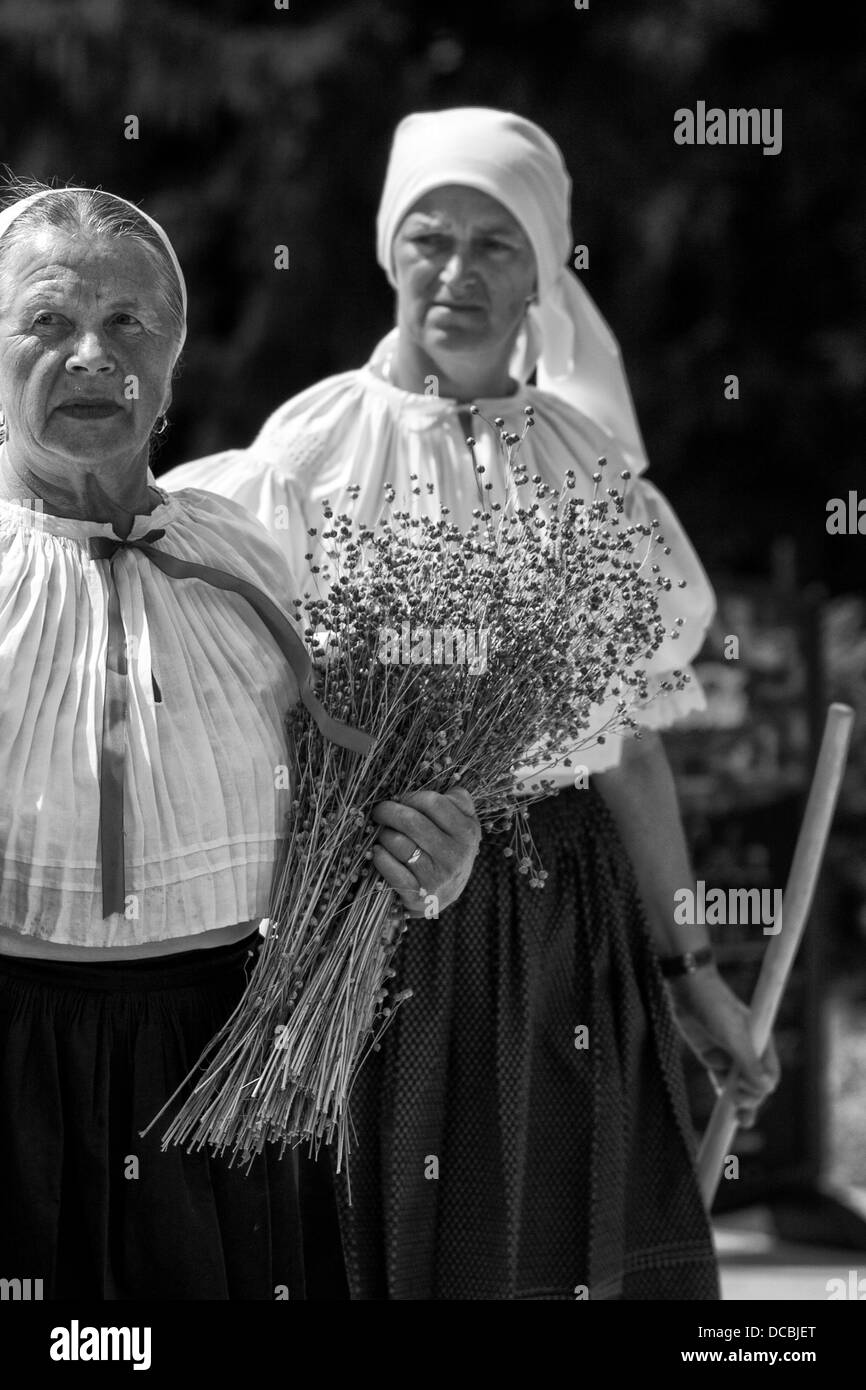 Le donne in costumi folk con la tenuta del lino nelle mani Foto Stock
