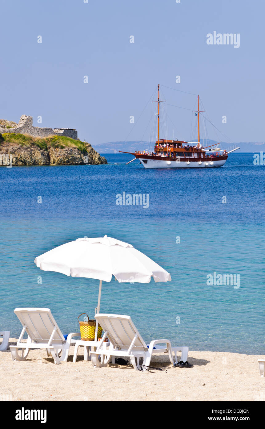 Nave al mare egeo di fronte alla spiaggia con le rovine della vecchia fortezza romana Foto Stock