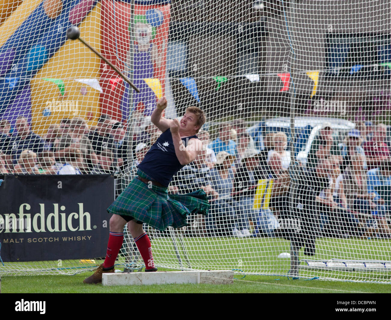 Ballater Scozia - 8 Agosto 2013: un concorrente di eseguire il lancio del martello a Ballater Highland Games. Foto Stock