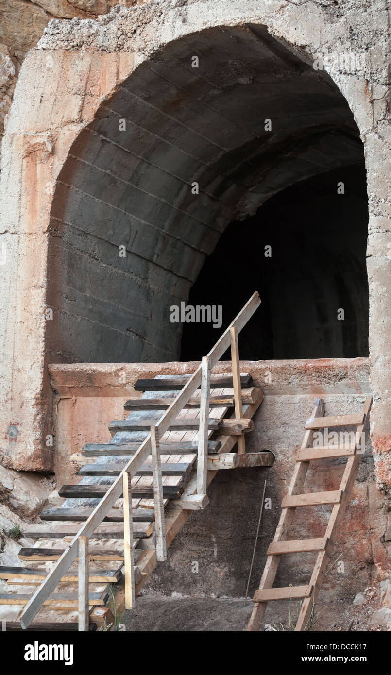 Portale scuro del vecchio cemento di tunnel nella roccia Foto Stock