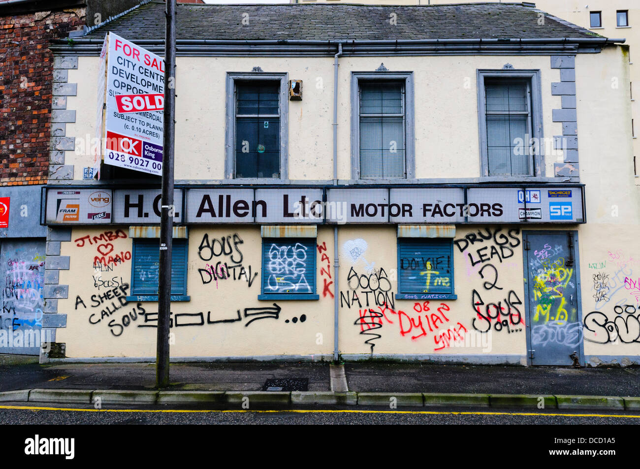 Graffiti su un chiuso verso il basso edificio retail compresi i riferimenti allo spaccio di droga ai concessionari Foto Stock