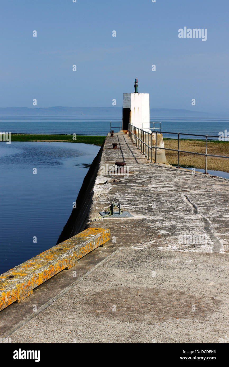 Una luce alla fine del molo a Nairn nelle Highlands della Scozia. Foto Stock