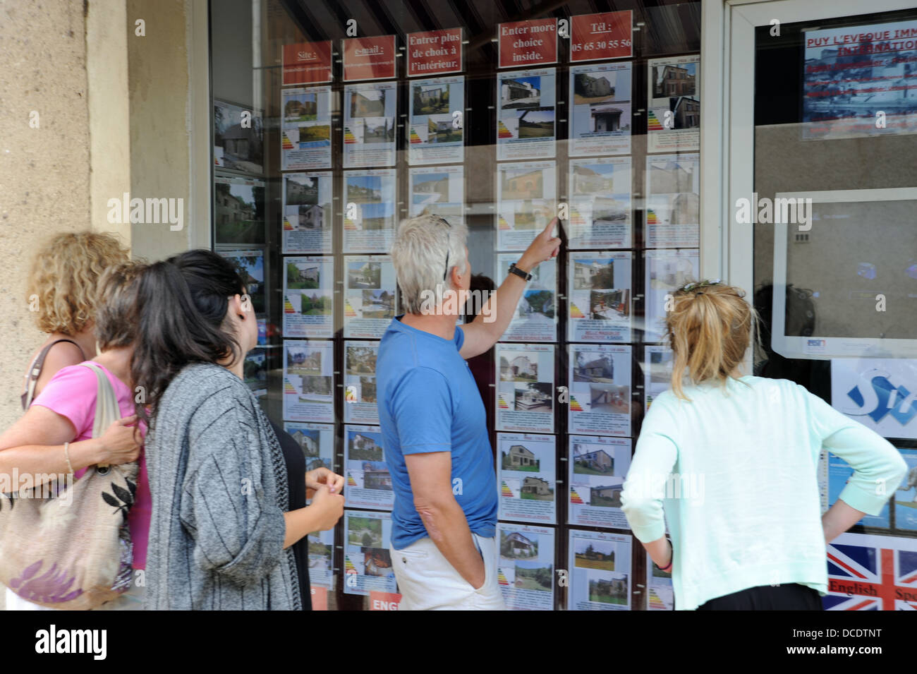 Famiglia guardando agente immobiliare per la finestra dei prezzi degli immobili in Puy L Eveque nel sacco Regione o dipartimento di Francia Foto Stock