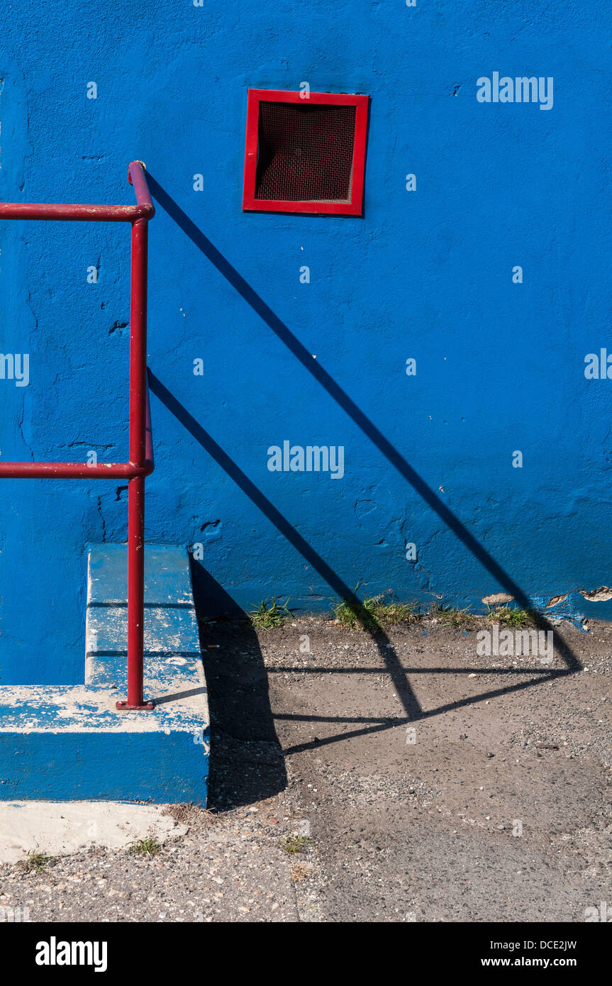Corrimano rosso parete blu Foto Stock