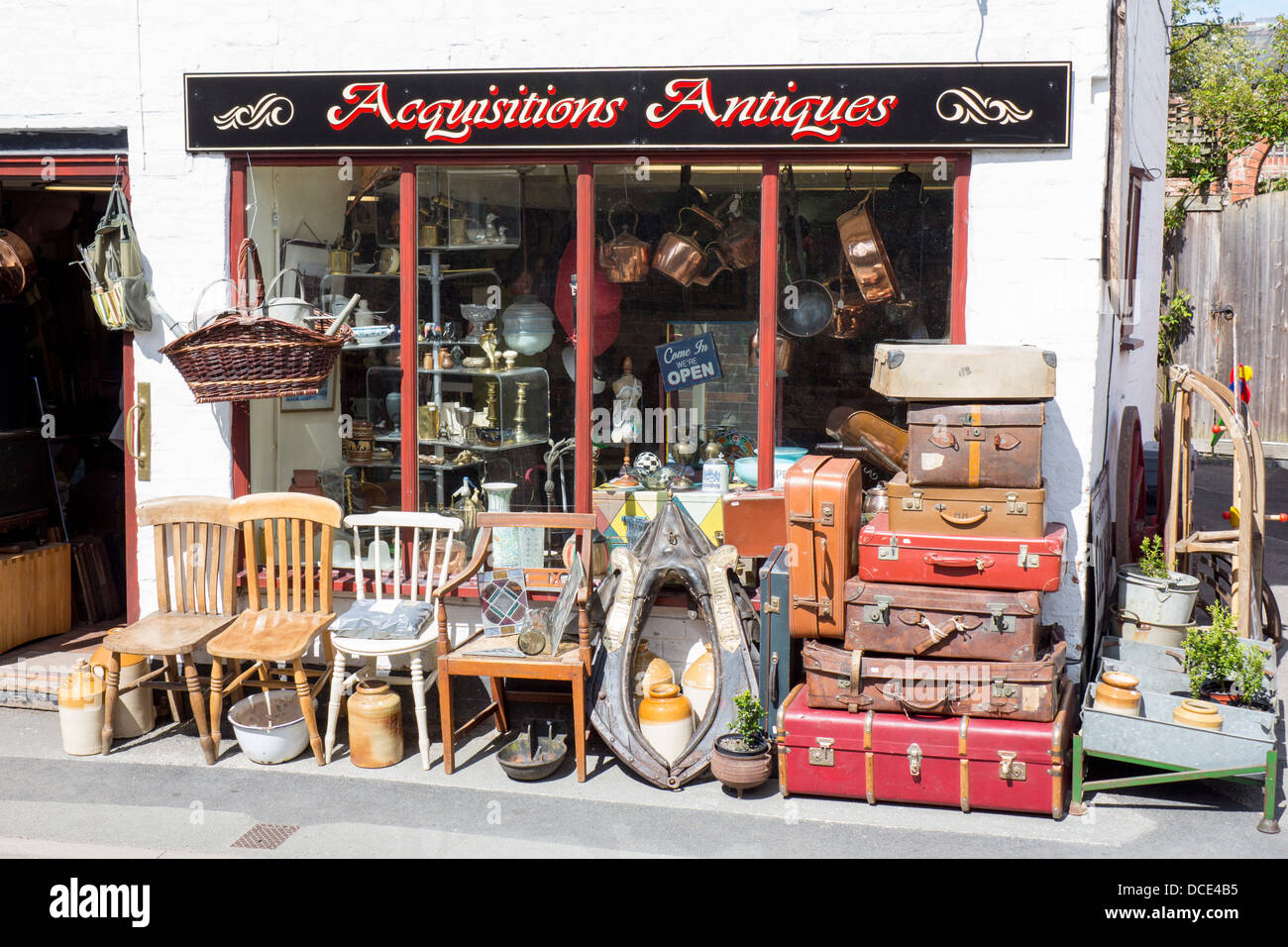 Negozio di antiquariato display esterno con sedie, pila di vecchie valigie e assortimento di articoli da emporio Tewkesbury Glos England Regno Unito Foto Stock
