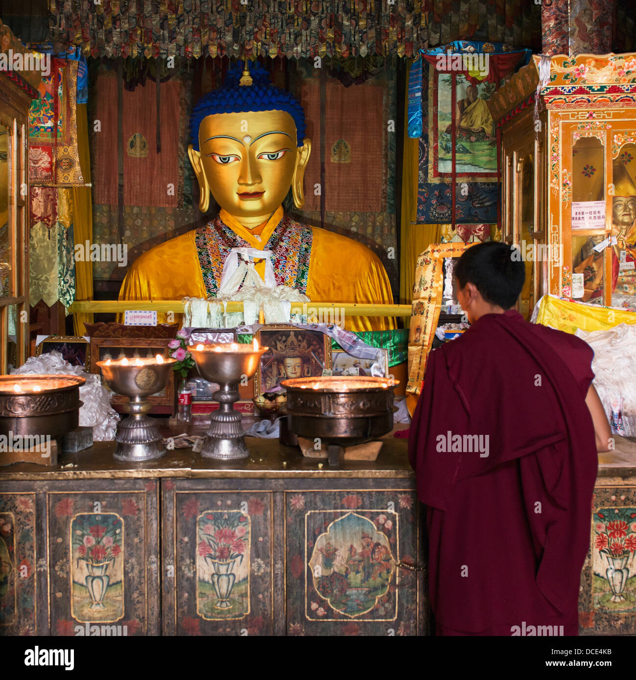 Cina, Xizang, Tibet, Monaco nella parte anteriore della statua di Buddha a Monastero di Drepung Foto Stock