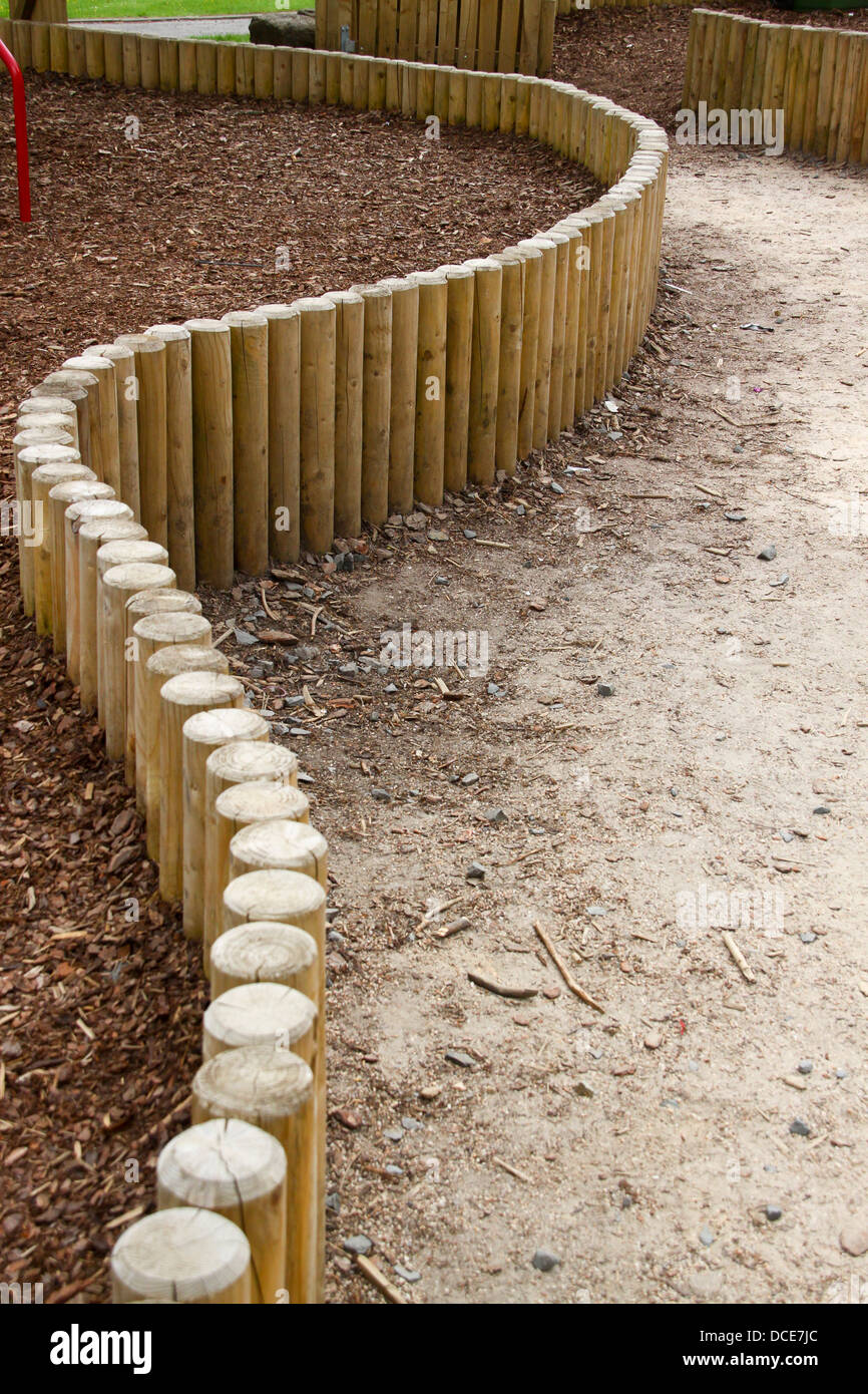 Curve log in legno recinto nel parco giochi Foto Stock