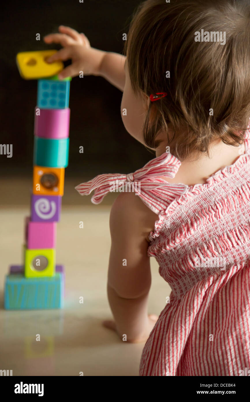Baby girl abilmente il bilanciamento dei blocchi di legno Foto Stock