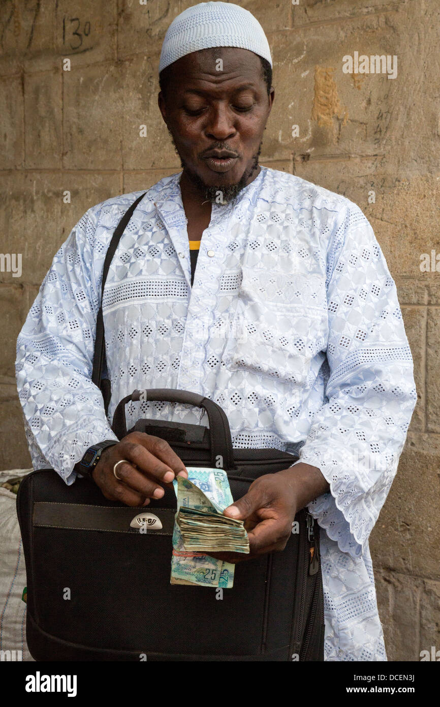 Anacardi acquirente contando il suo denaro, Fass Njaga Choi, Gambia Foto Stock