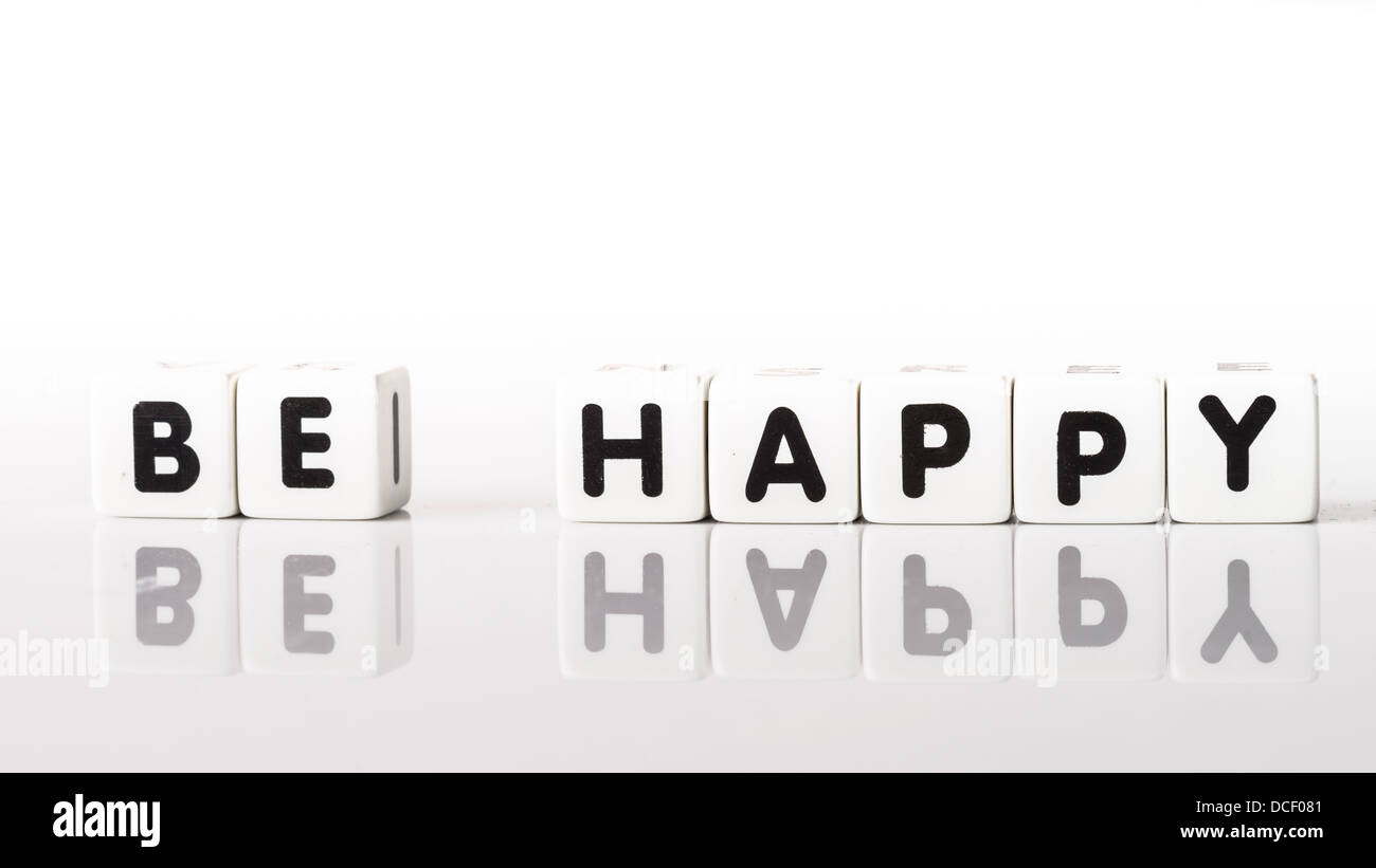Essere felice scritto in lettere nere si riflette su sfondo bianco Foto Stock
