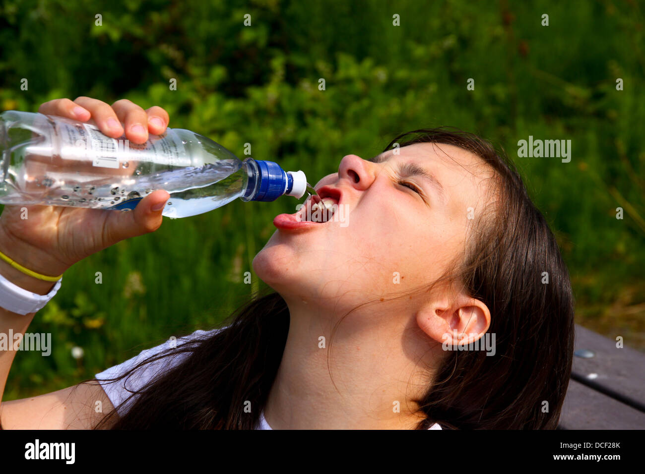 Ragazza giovane gulping acqua dalla bottiglia di sport Foto Stock