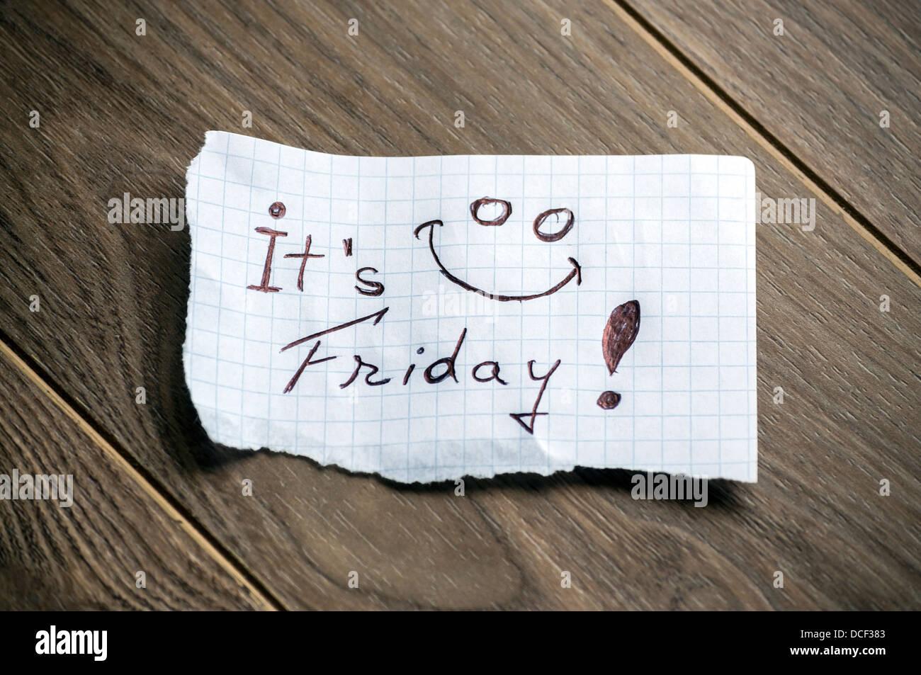 È venerdì - La scrittura a mano il testo su un pezzo di carta su uno sfondo di legno Foto Stock