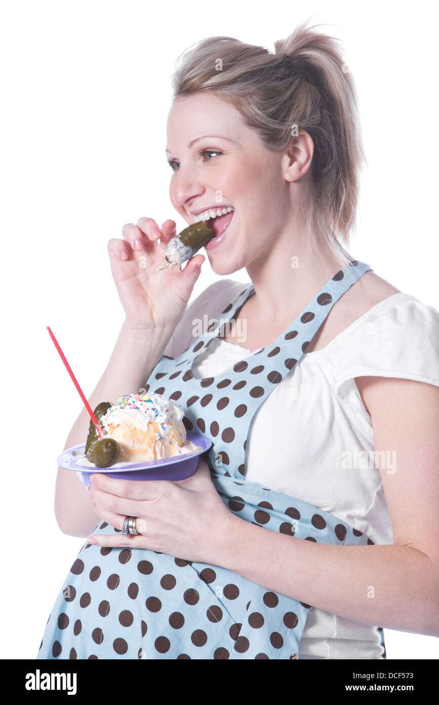 Donna incinta con gelato e sottaceti Foto Stock