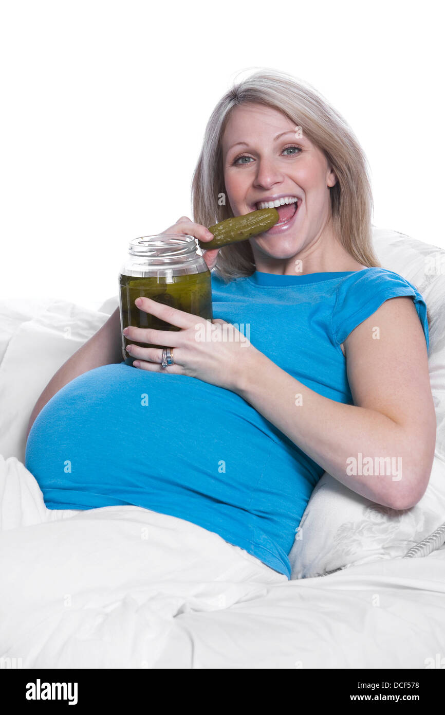 Donna incinta mangiare sottaceti Foto Stock
