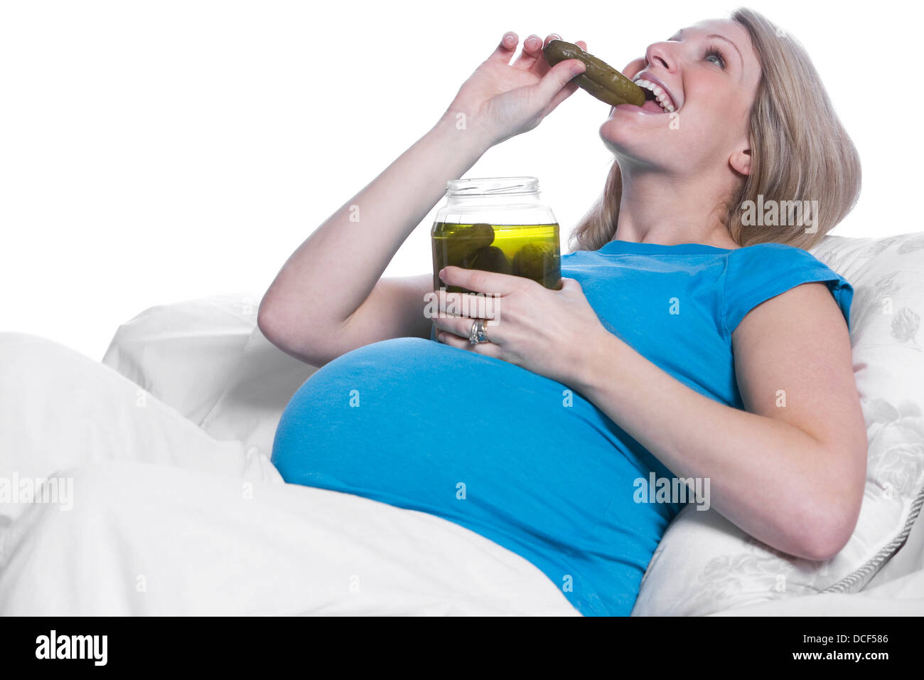 Donna incinta mangiare sottaceti Foto Stock