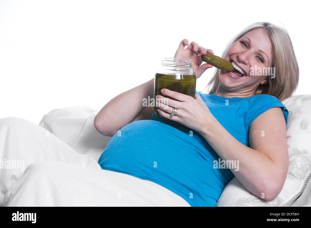 Donna incinta mangiare sottaceti Foto Stock