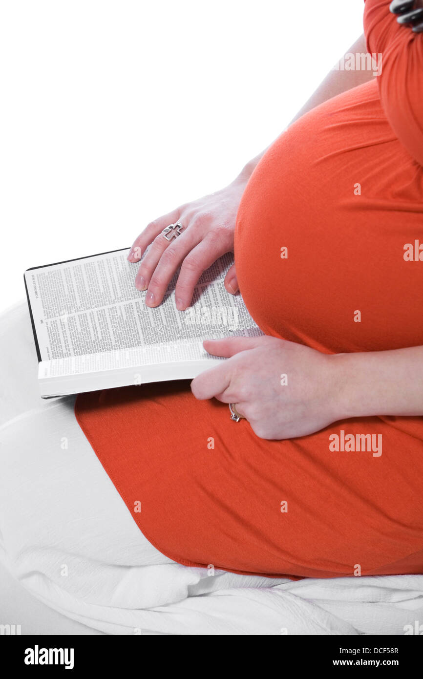 Donna Incinta della lettura della Bibbia Foto Stock