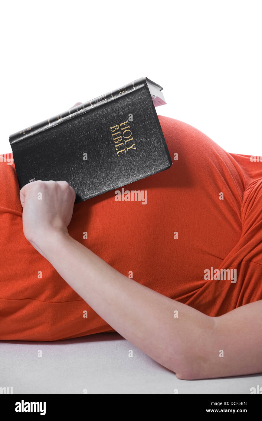 Donna incinta con la Bibbia sul suo ventre Foto Stock