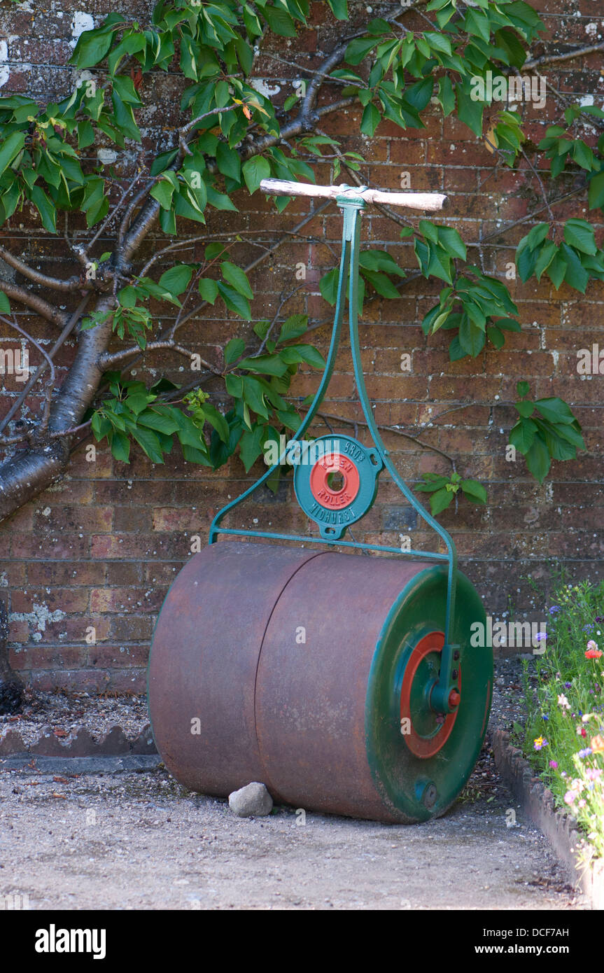 Allin Bro il vecchio rullo da giardino appoggiato su di un muro di mattoni Foto Stock