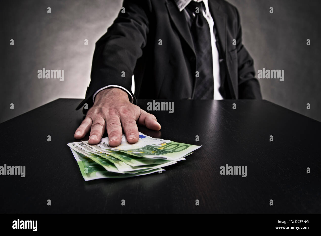 Oggetto corruzione: mano spinge le fatture in euro al di sopra della tabella. Foto Stock