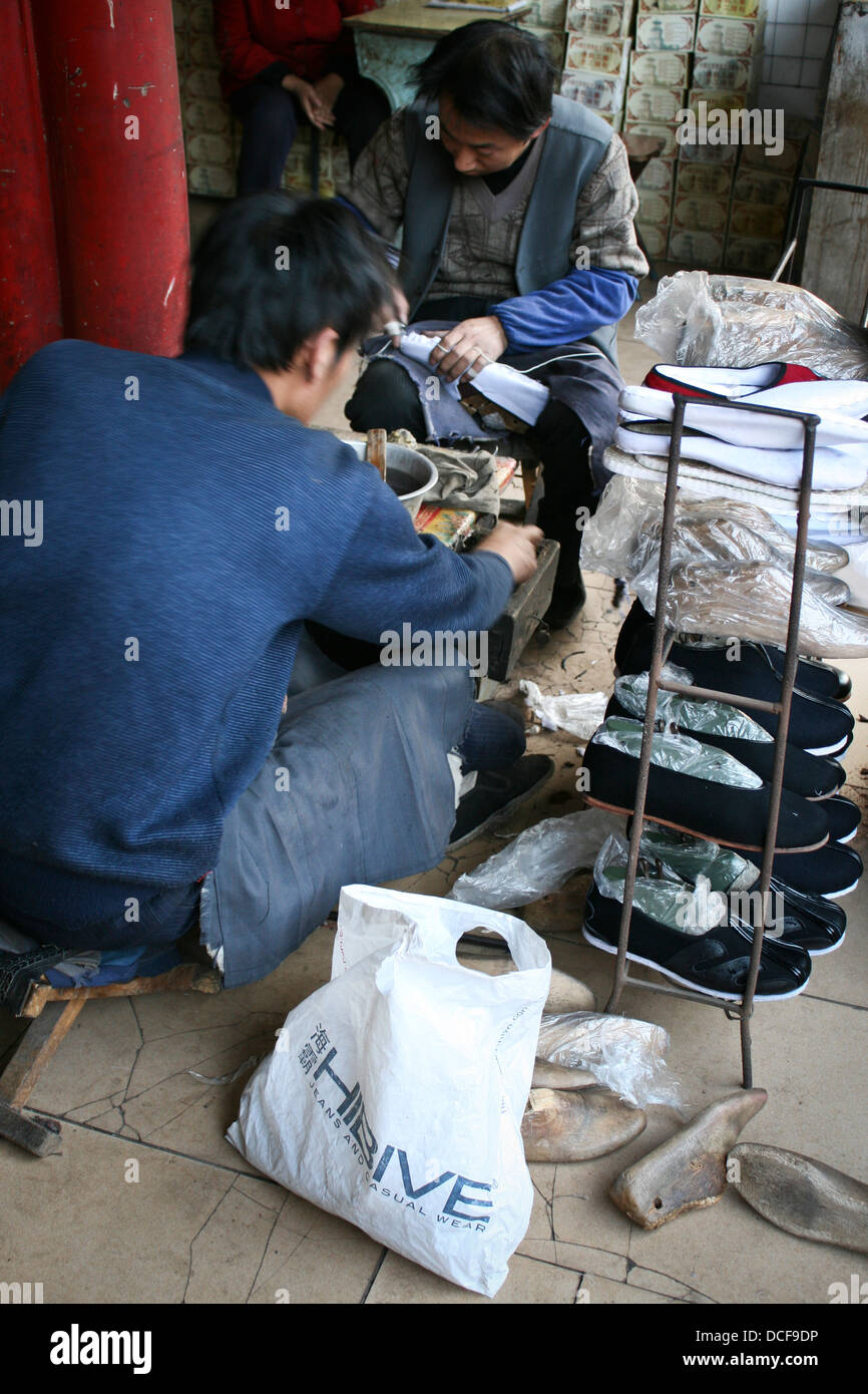 Un uomo fa di scarpe in Ping Yao, Cina Foto Stock