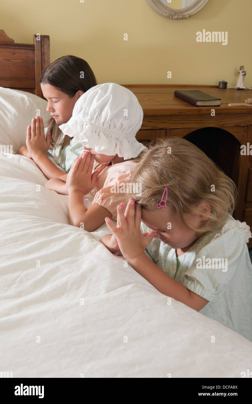 Le tre sorelle facendo loro preghiere prima di addormentarsi Foto Stock