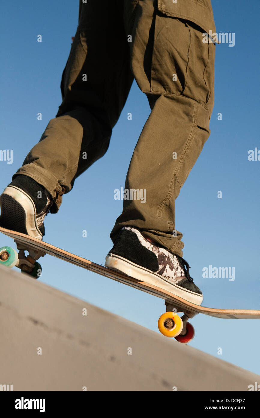 Basso angolo vista del giovane maschio guidatore di skateboard Foto Stock