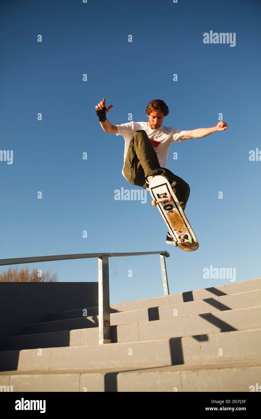 Basso angolo vista del giovane maschio guidatore di skateboard Foto Stock