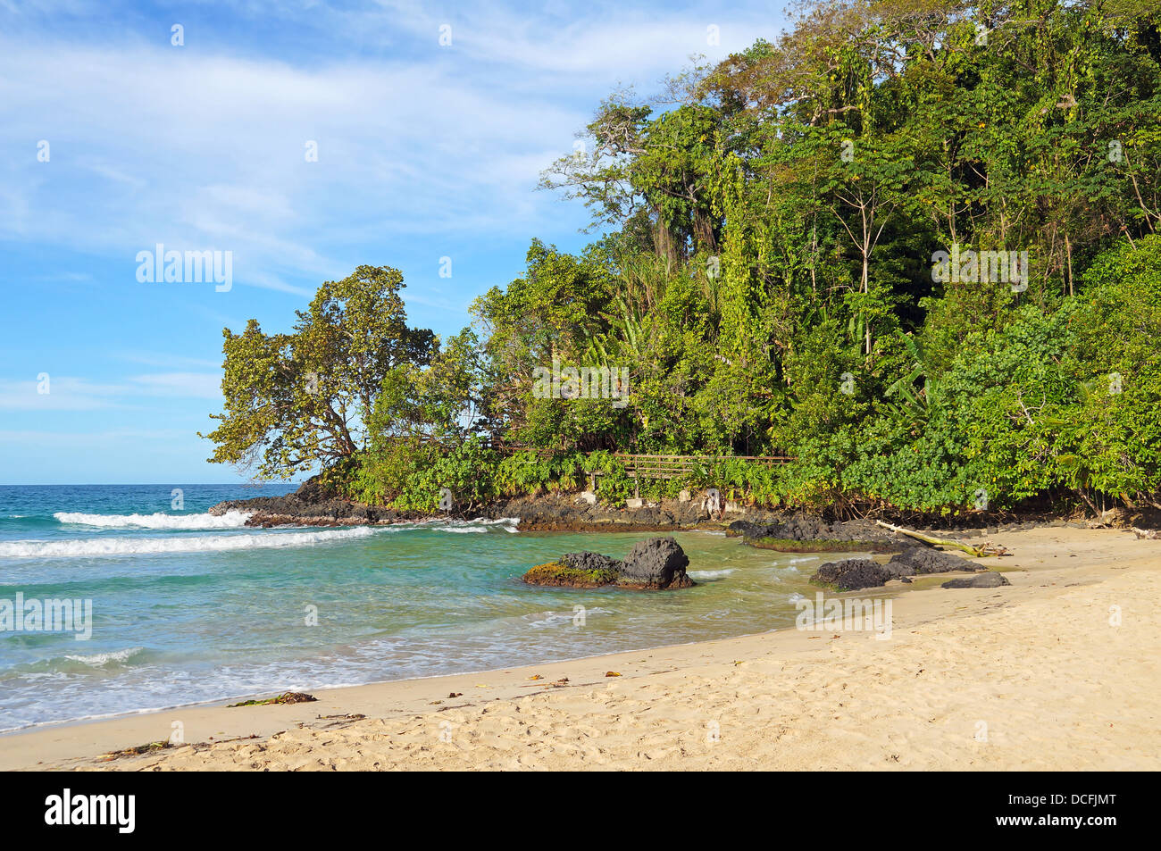 Bella spiaggia tropicale con vegetazione lussureggiante in background Foto Stock