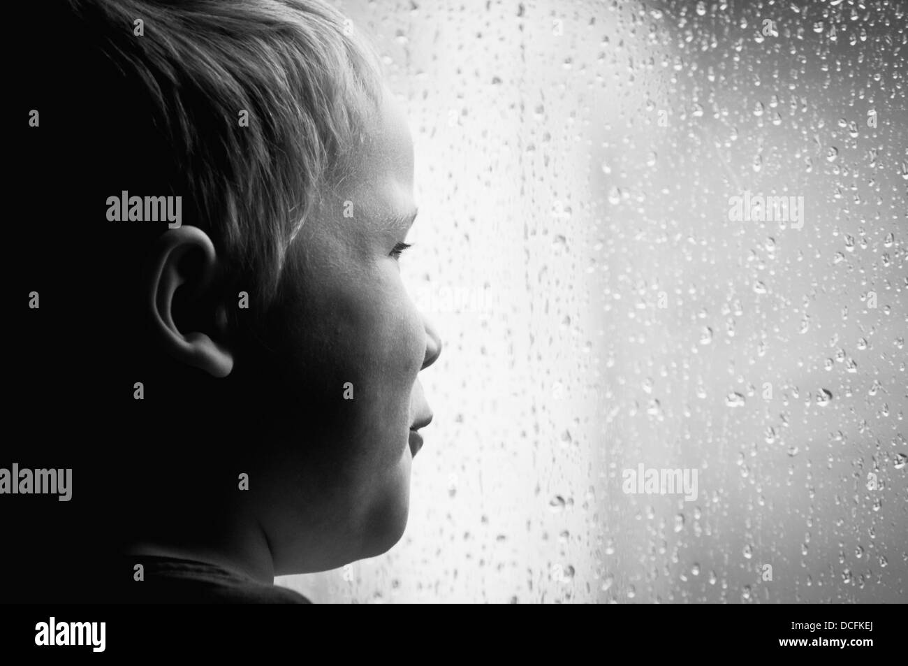 Bambino guardando la pioggia Foto Stock