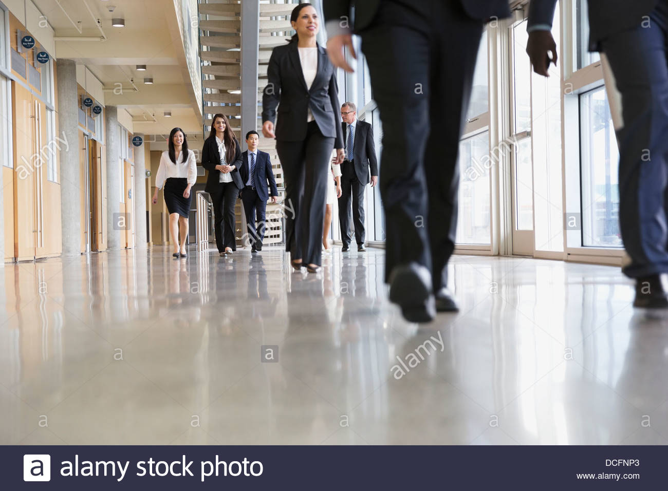 Un gruppo di persone di affari a piedi nella costruzione di ufficio Foto Stock