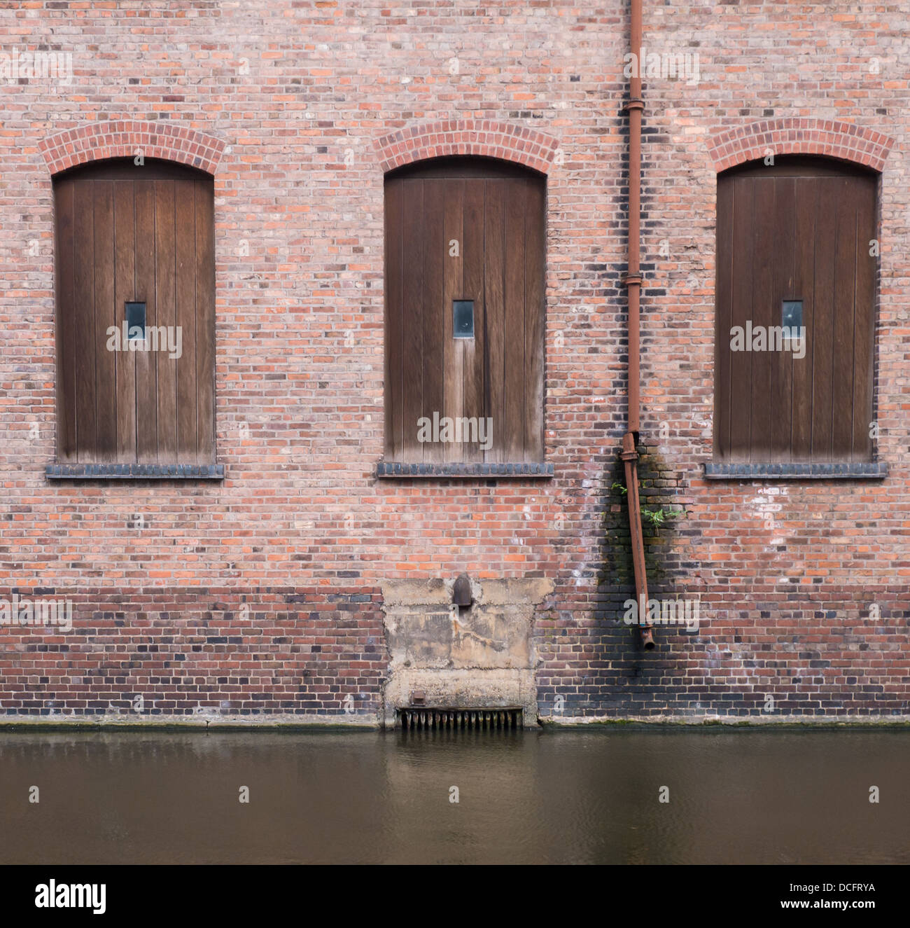Marrone porte in legno sul lato di un vecchio edificio di mattoni rossi a fianco del canale di Nottingham. Foto Stock