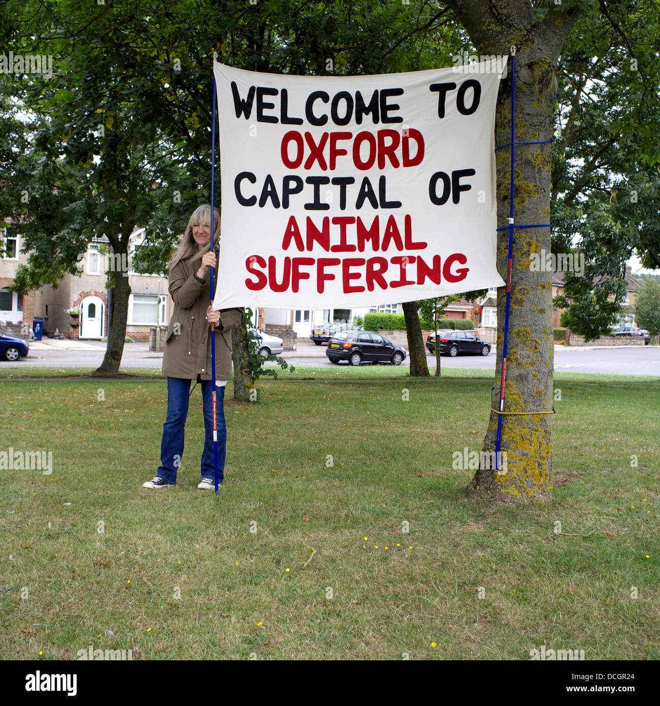 Oxford, Regno Unito. 17 Ago, 2013. Parlare dei diritti degli animali attivista, Ann, tenere un cartello che dice "Benvenuto a Oxford Capitale della sofferenza animale", ha proteste contro Oxford University laboratorio animali sabato 17 agosto 2013 lungo l'anello di Oxford road, Inghilterra http://speakcampaigns.org Credit: Jack Cox nella campagna inglese/Alamy Live News Foto Stock