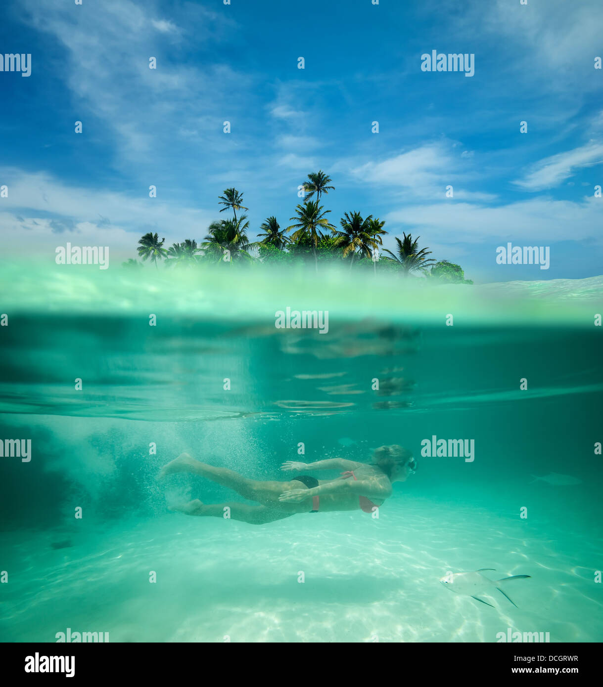 La donna lo snorkeling in una laguna tropicale Foto Stock