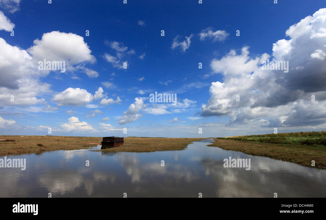 Vecchia casa galleggiante sotto un cielo estivo ad alta marea a Burnham Deepdale sulla Costa North Norfolk. Foto Stock
