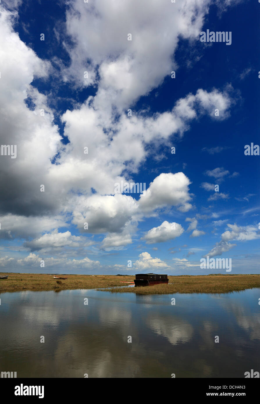 Vecchia casa galleggiante sotto un cielo estivo ad alta marea a Burnham Deepdale sulla Costa North Norfolk. Foto Stock
