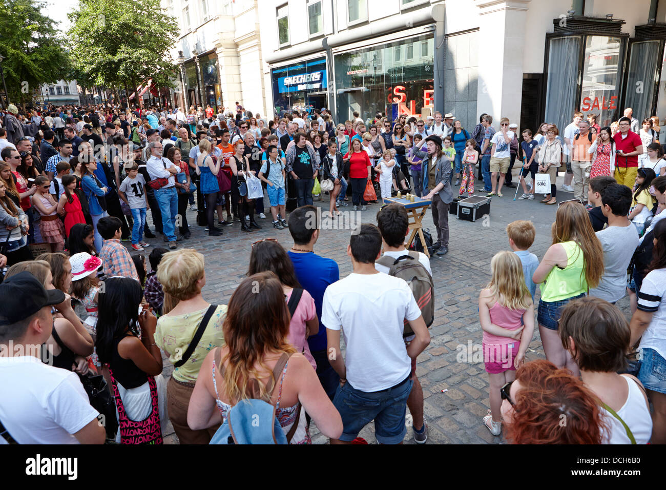 La folla intorno a via performer Londra Inghilterra REGNO UNITO Foto Stock