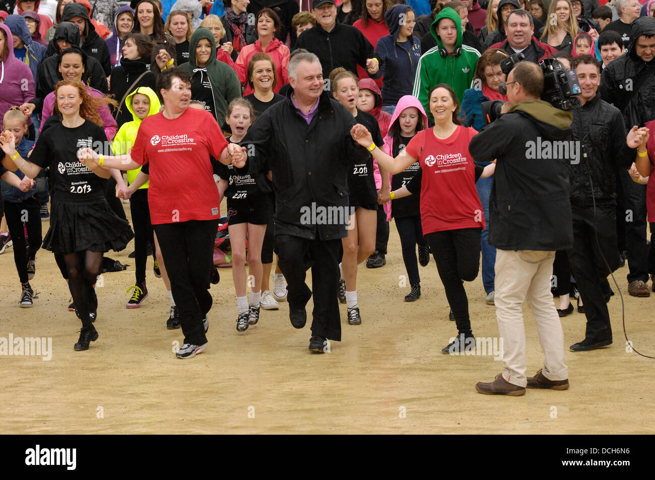 Derry, Londonderry, Irlanda del Nord, 18 agosto 2013 il presentatore TV Eamonn Holmes a battere i record di Riverdance routine. ITV presenter Eamonn Holmes era tra 2569 ballerini irlandesi che hanno completato una maschera di luce per 5 minuti e mezzo per raggiungere il Guinness dei primati record del mondo per la più lunga Riverdance. Il precedente record di 1693 ballerini è stato raggiunto a Dublino il 21 luglio 2013. Credito: George Sweeney / Alamy Live News Foto Stock