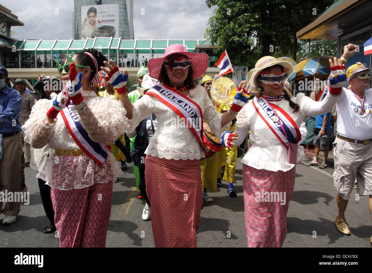 Il 18 agosto 2013. Bangkok , Thailandia . Governo anti-manifestanti in abito tradizionale sfilata durante una dimostrazione . I manifestanti che indossano "Guy Fawkes maschera' continuare al rally di un quartiere dello shopping nel centro di Bangkok. I dimostranti si sono riuniti per un rally contro l ex Premier Thaksin Shinawatra e amnesty bollette per la violenza politica. Foto Stock